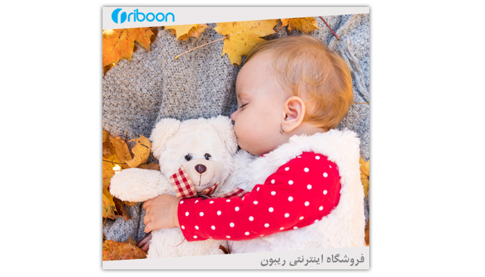 نوزاد با لباس از پارچه تدی سفید با عروسک تدی خوابیده